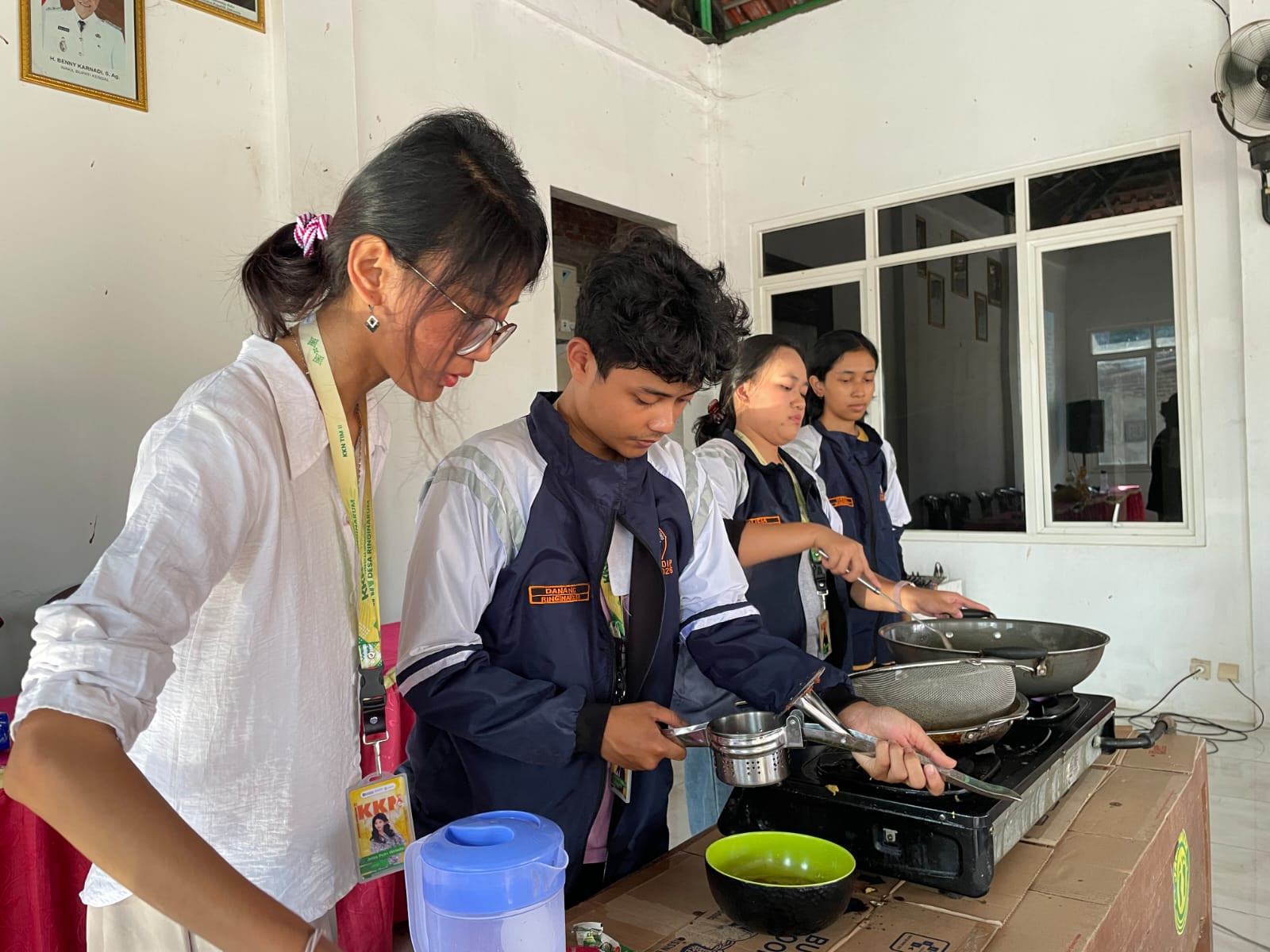 Peserta bersama mahasiswa KKN mempraktikkan proses pengolahan lele dalam pelatihan pembuatan abon lele.